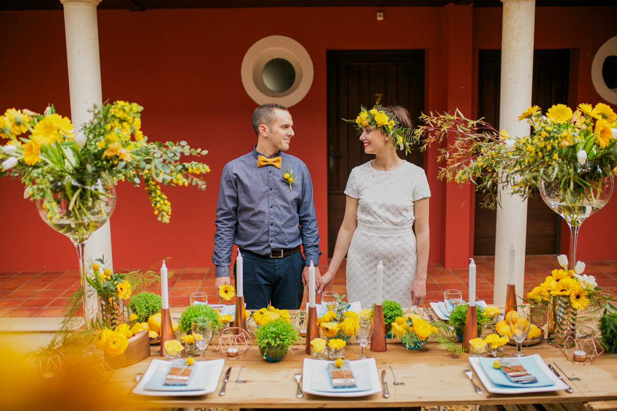 Centre de table de mariage avec le jaune et le cuivre comme thème de déco et aux fleurs de renoncule et de rose.
