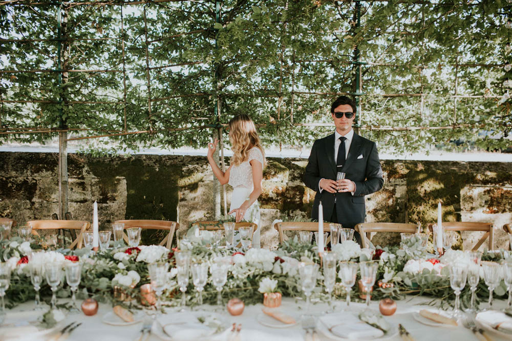 Centre et chemin de table de réception de mariage bohème avec le feuillage d'eucalyptus, des fleurs d'hortensia et des bougies romantique.