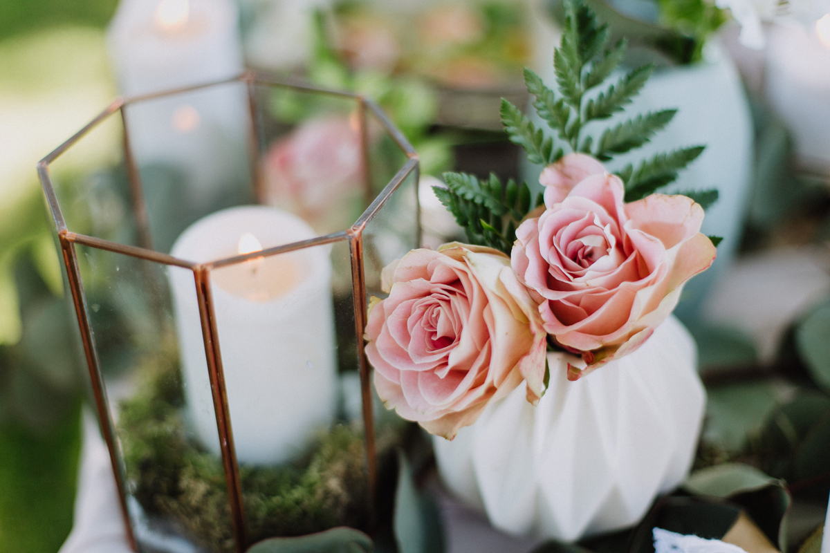 Composition florale en roses au thème bucolique, chic et végétal d'un mariage à la réception en extérieur.