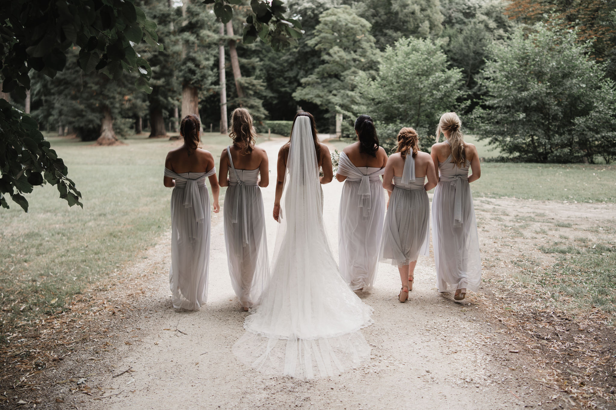 Photographie de mariage avec la mariée et ses demoiselles d'honneur dans le jardin du Château de Gironde.