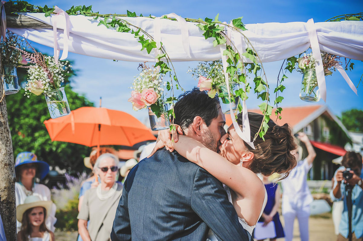 Cérémonie de mariage sur la plage du Cap Ferret avec des fleurs de décoration et du feuillage d'eucalyptus.