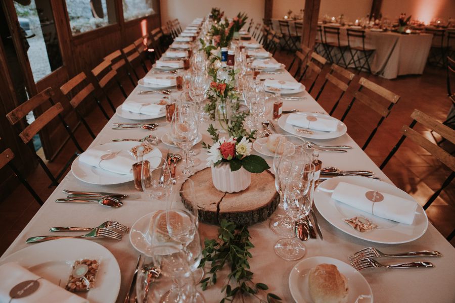 Centre de table en bois et bouquets simples de mariage champêtre dans un lieu de réception atypique en Aquitaine.