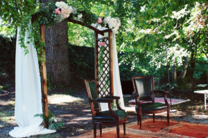 Décoration Mariage Extérieur Dans Un Jardin Champêtre Avec Une Arche De Cérémonie Aux Bouquets Et Fleurs Romantique Chic.