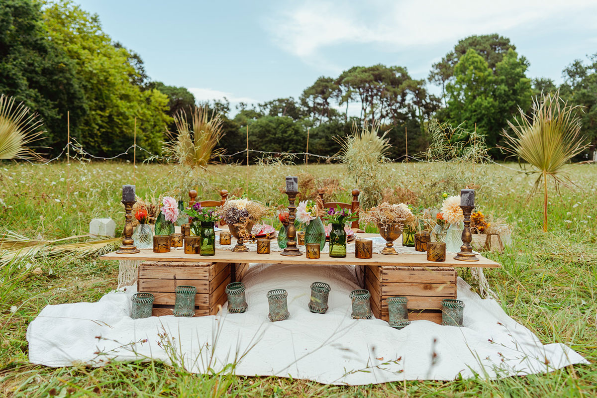Décoration mariage en fleurs séchées et une table d'honneur des mariés dans un champs en pleine forêt à l'extérieur pour un décor naturel de luxe au Pays Basque.