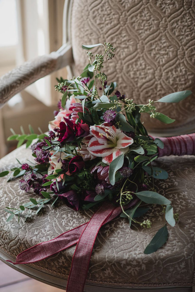Mariage en octobre et bouquet de fleurs en astrance de couleur violet avec du feuillage d'eucalyptus.