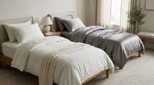 Deux lits jumeaux avec draps blanc et gris dans chambre moderne