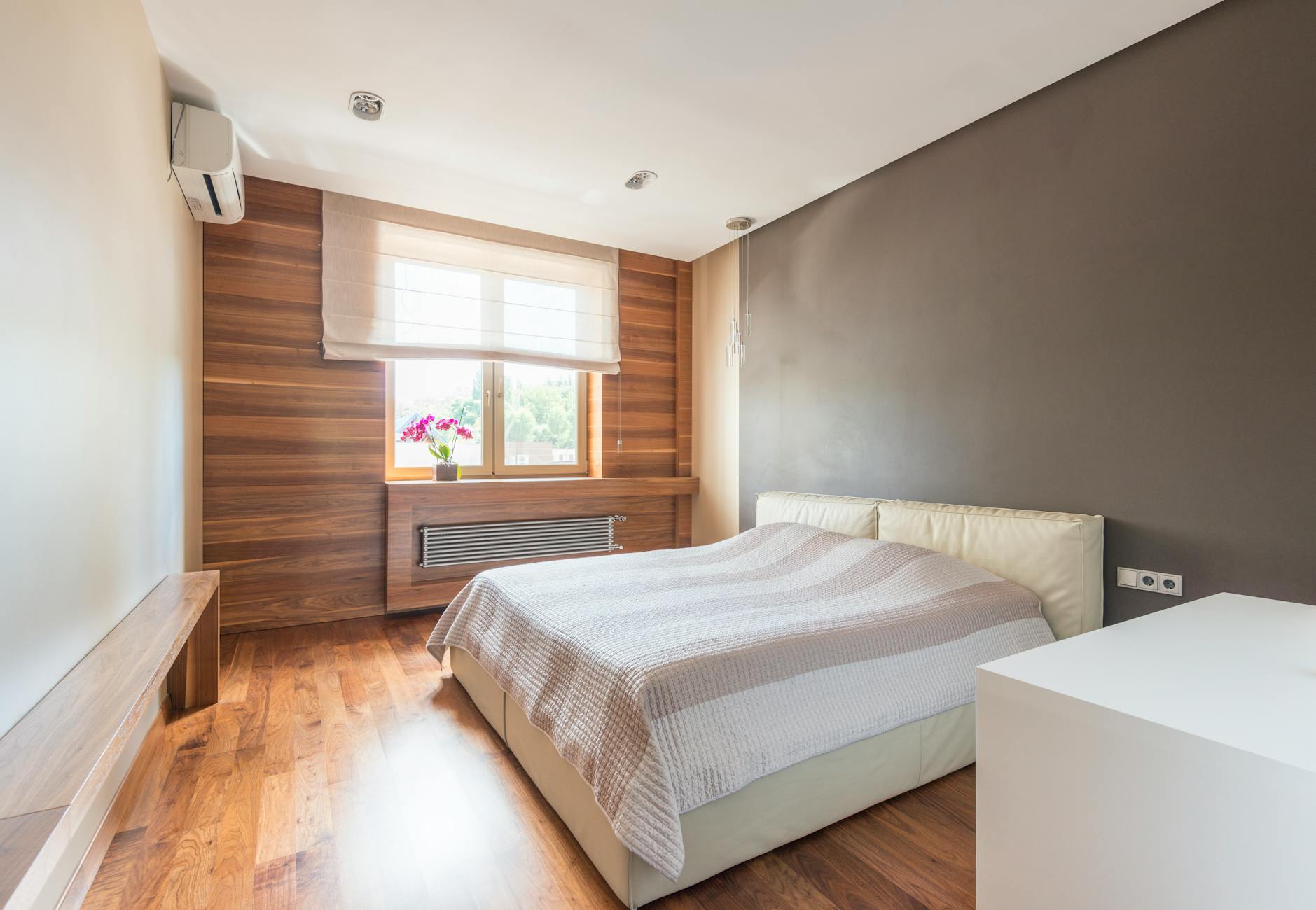 Chambre chaleureuse avec mur en bois recyclé derrière le lit style rustique