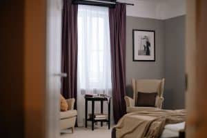 Chambre vert sauge et bois clair avec linge de lit naturel et plantes vertes